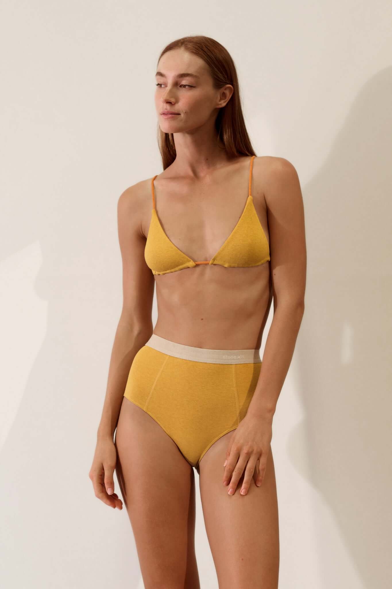 Hi Brief in Organic Cotton Rib - Mustard and Sand model showcasing comfort with high-waisted design and soft organic cotton fabric.