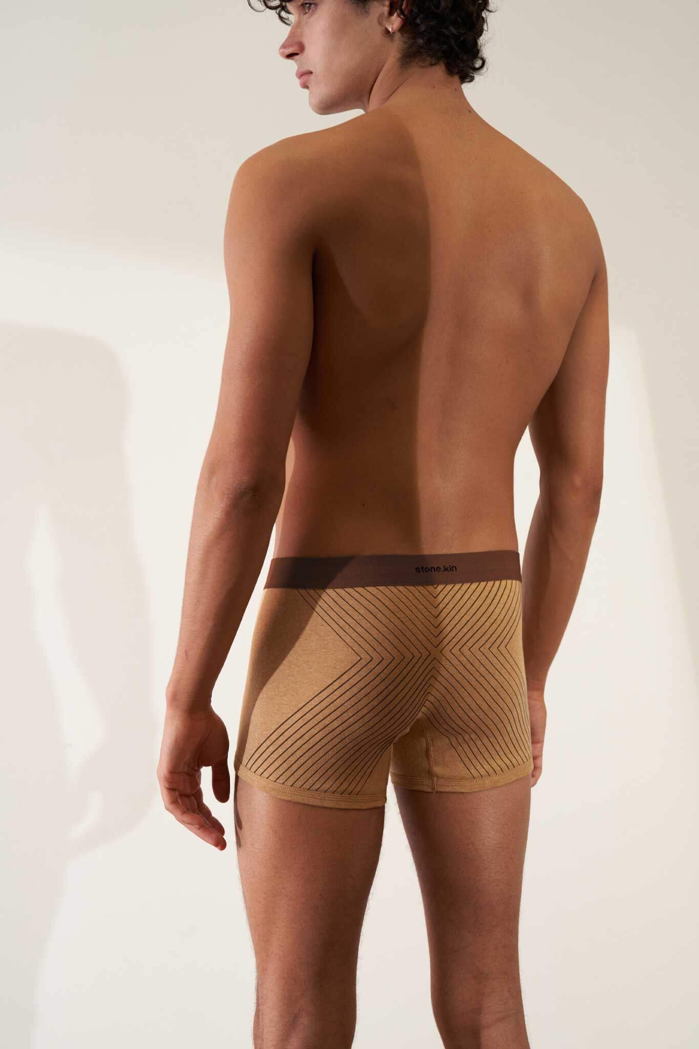 Boxer briefs in organic cotton rib, camel color with brown cross, showcasing comfort and GOTS certification.