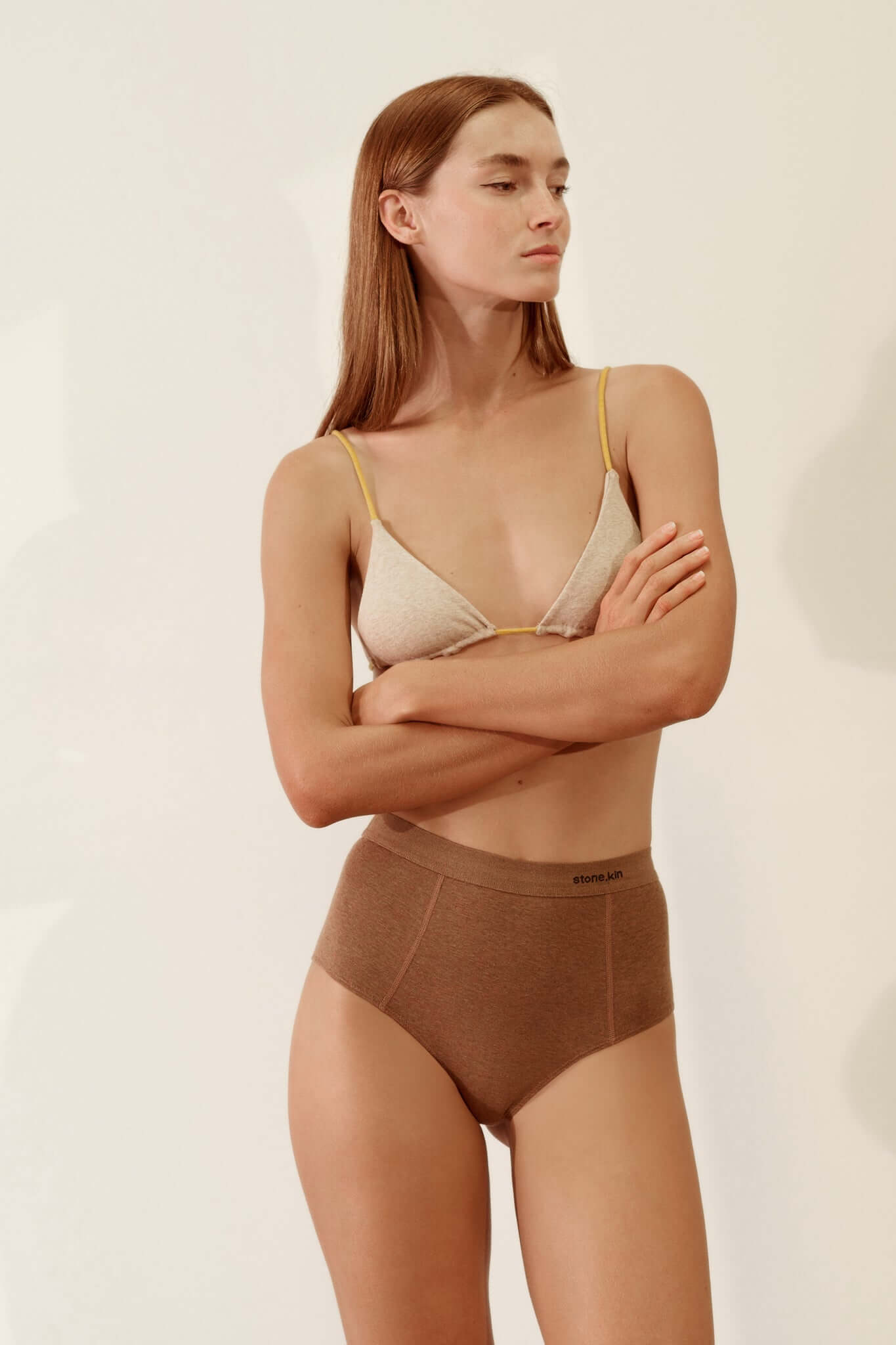 Model wearing a Triangle Bralette in Organic Cotton Rib – Sand / Mustard paired with brown high-waisted underwear.