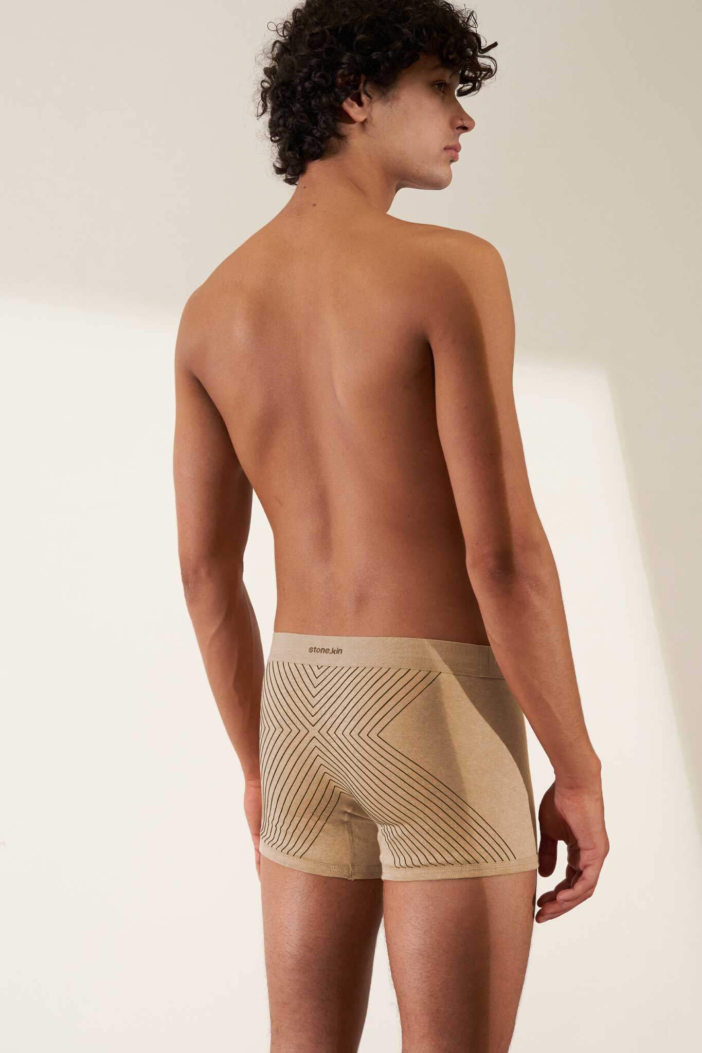Men's boxer brief in organic cotton rib, sand melange rib with tar cross, offering comfort and GOTS certification.