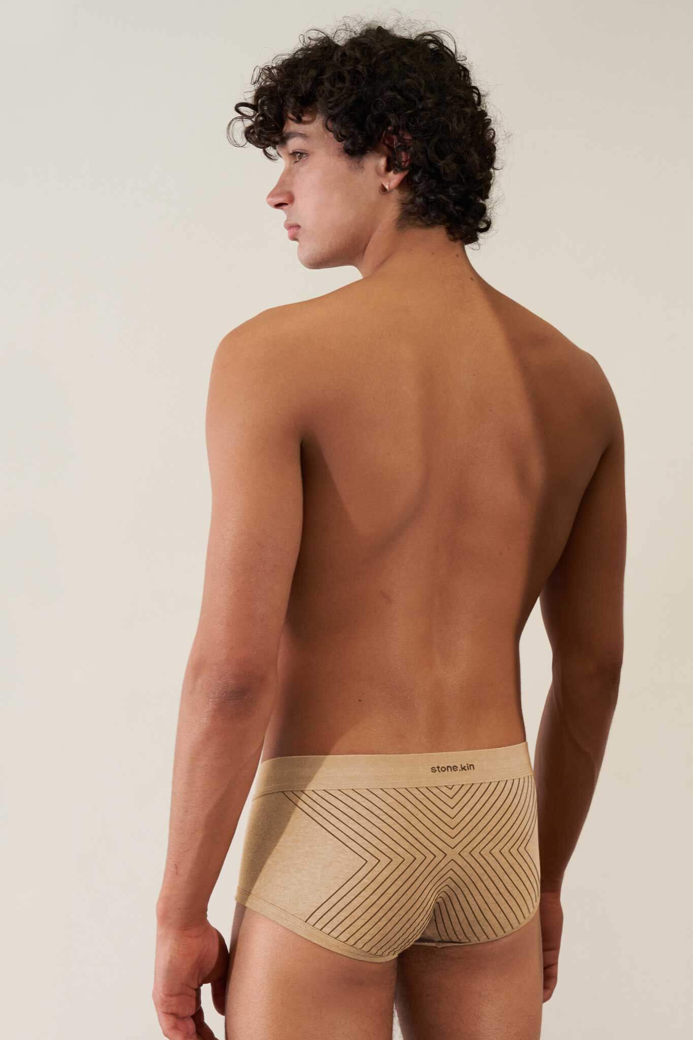 Man wearing organic cotton rib trunk in Sand with Tar Cross, showcasing comfort and GOTS certification.