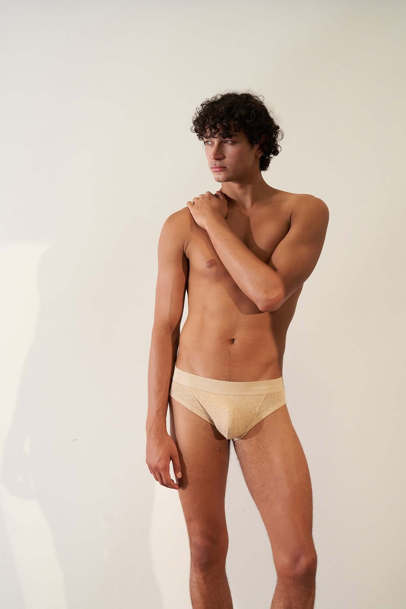 Male model wearing a tailored brief made of GOTS certified organic cotton in sand color for ultimate comfort.