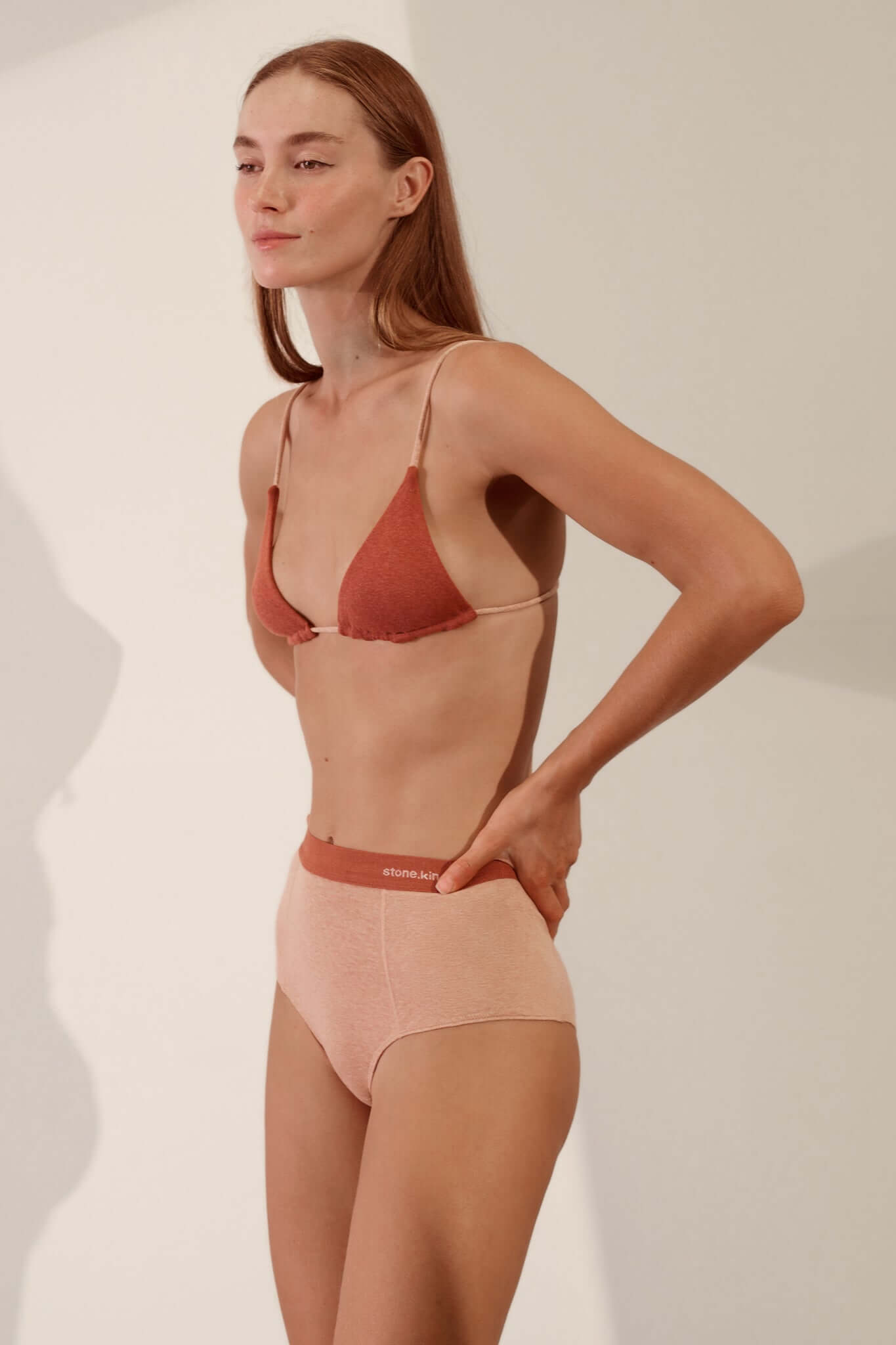 Triangle Bralette in Organic Cotton Rib - Rust / Nude model wearing bralette and high-waisted panties, showcasing soft fabric.