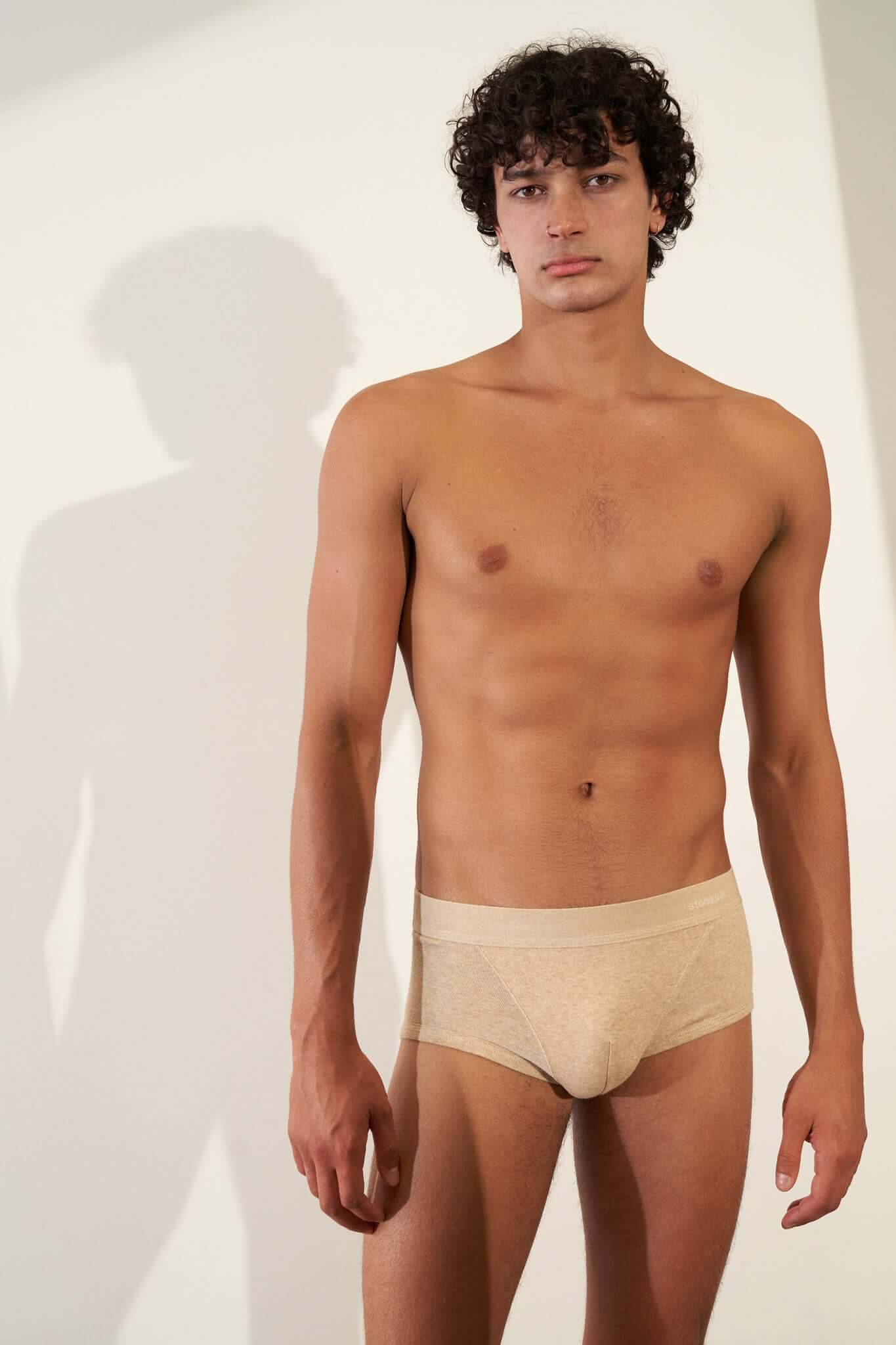 Model wearing organic cotton rib trunk in sand color, showcasing comfort and GOTS certified fabric.